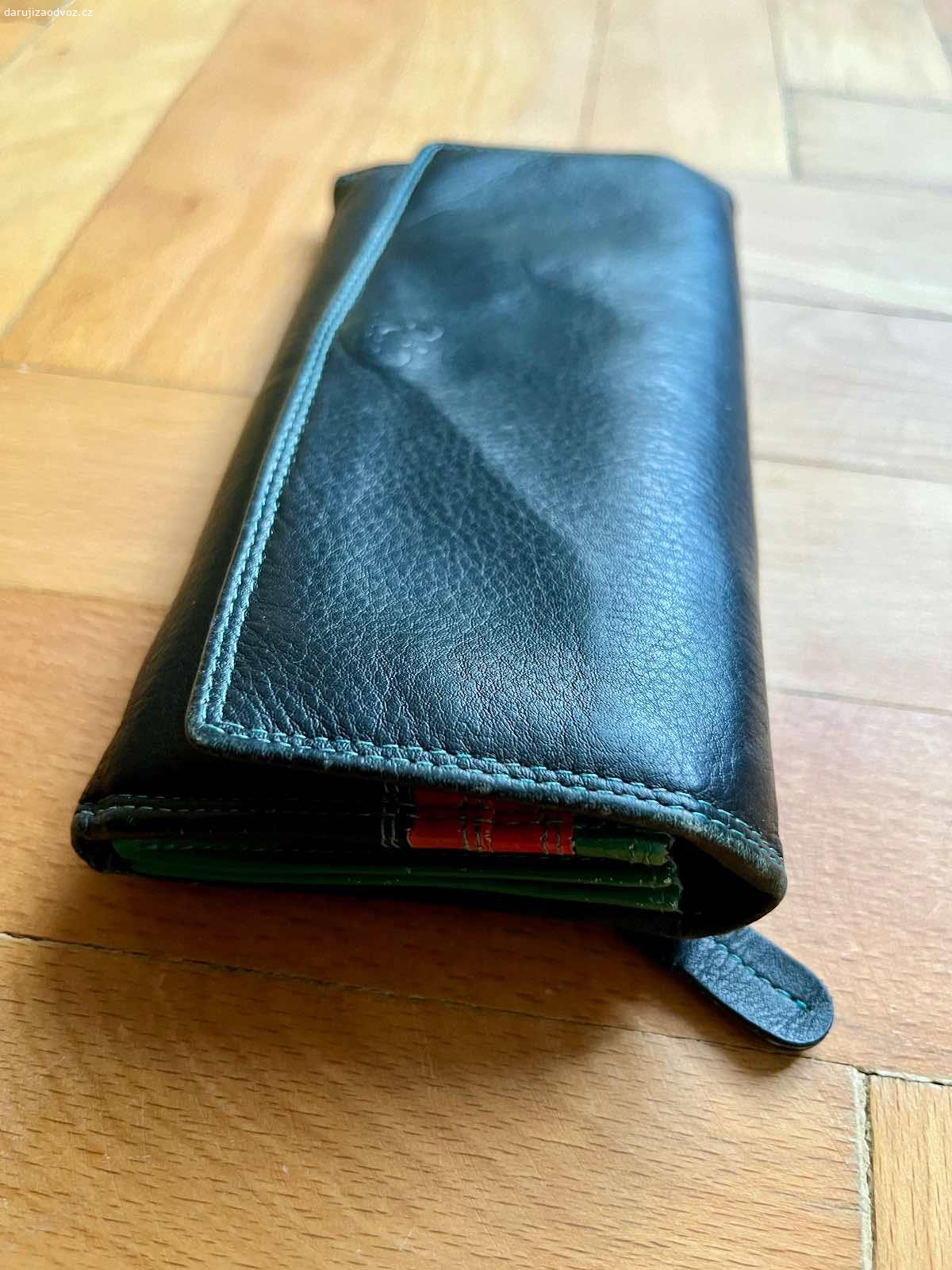 Dámská kožená peněženka. Daruji dámskou koženou peněženku, která nese stopy opotřebení. Veškeré zipy funkční, jen je prasklá fólie na fotografie.