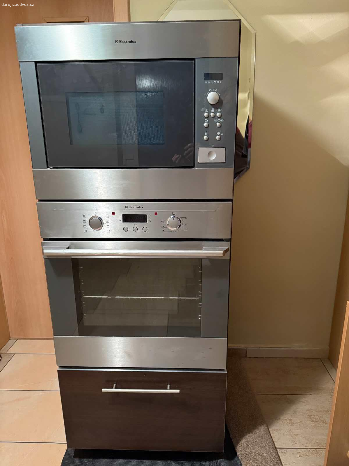 Daruji část kuchyňské linky s troubami. Mikrovlnná trouba Electrolux s rozmrazováním a pečící trouba Electrolux s rozmrazováním, horkým vzduchem a grilem v kuchyňské skříni, používané 15 roků a stále bez problémů funkční.