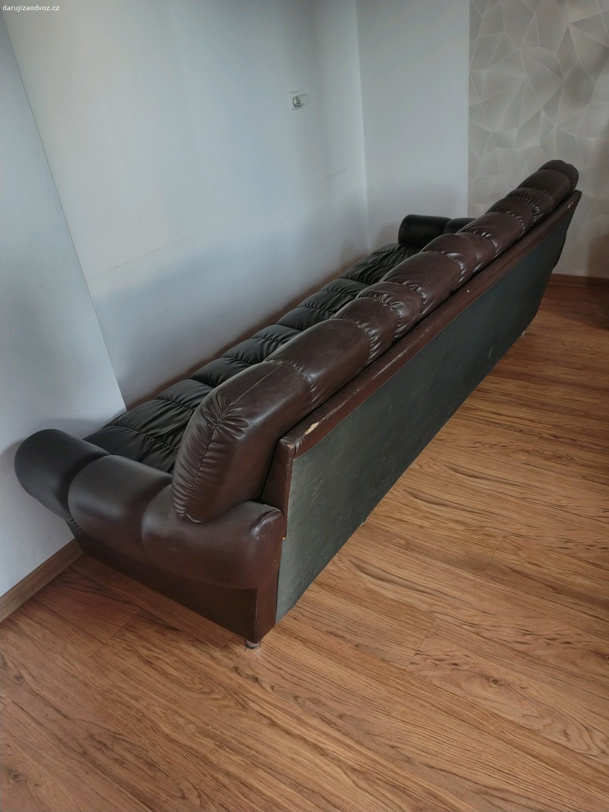 Daruji koženkovou sedačku. Daruji prostornou čtyřmístnou sedačku z koženky v tmavě hnědé barvě. Délka 230 cm. Má běžné známky opotřebení a drobné kosmetické vady, viz foto.