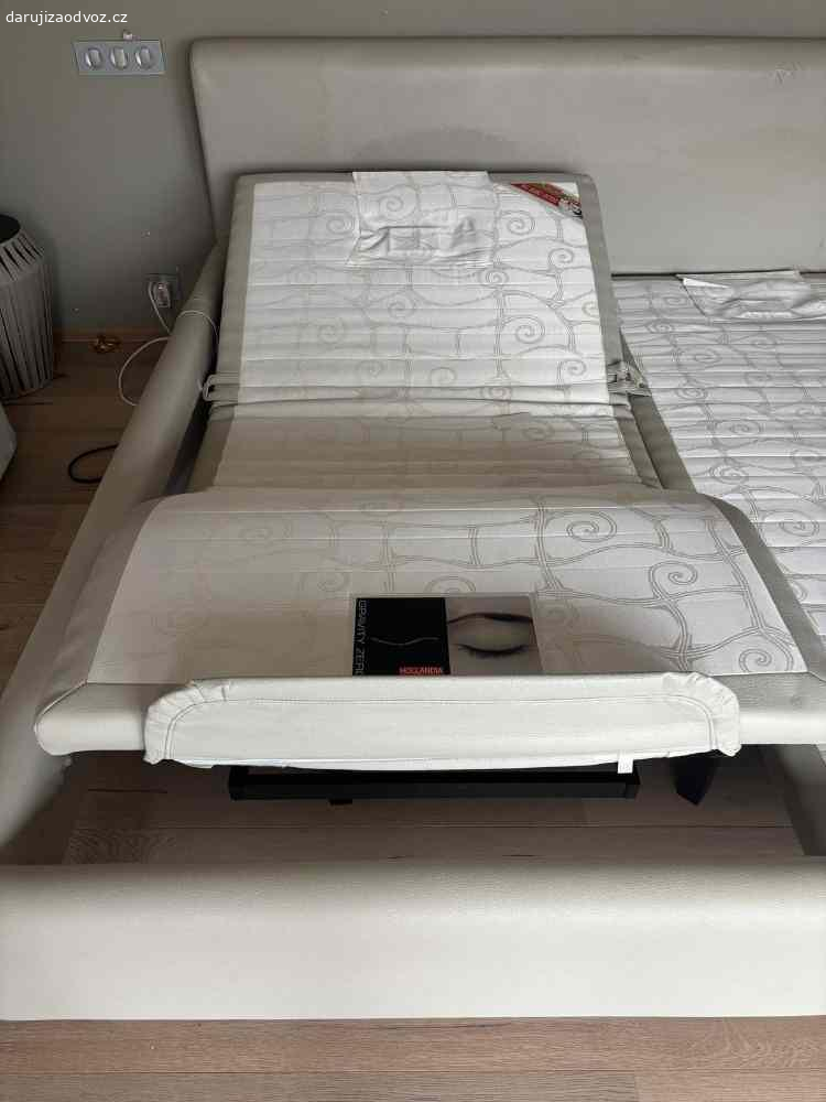 Daruji  postel king size zn.Hollandia. Nabízím velkou (200x200) postel zn.Hollandia, s polohovacími rošty (bez matrací). Povrchová úprava kůže /v čele lehce popraskaná). JInak je postel  v dobrém stavu (koupě r.2014).