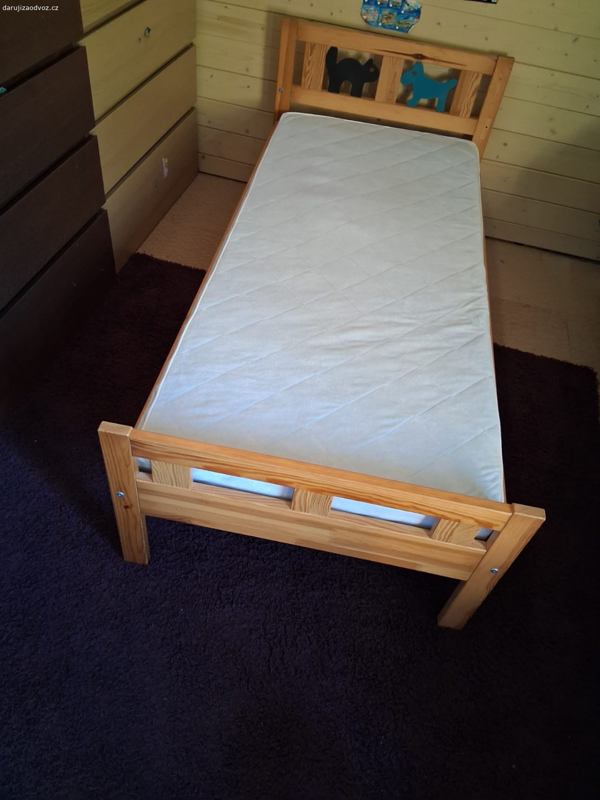 Dětská postel. U boční zábrany chybí šroub. Rýhy v bočnici.
