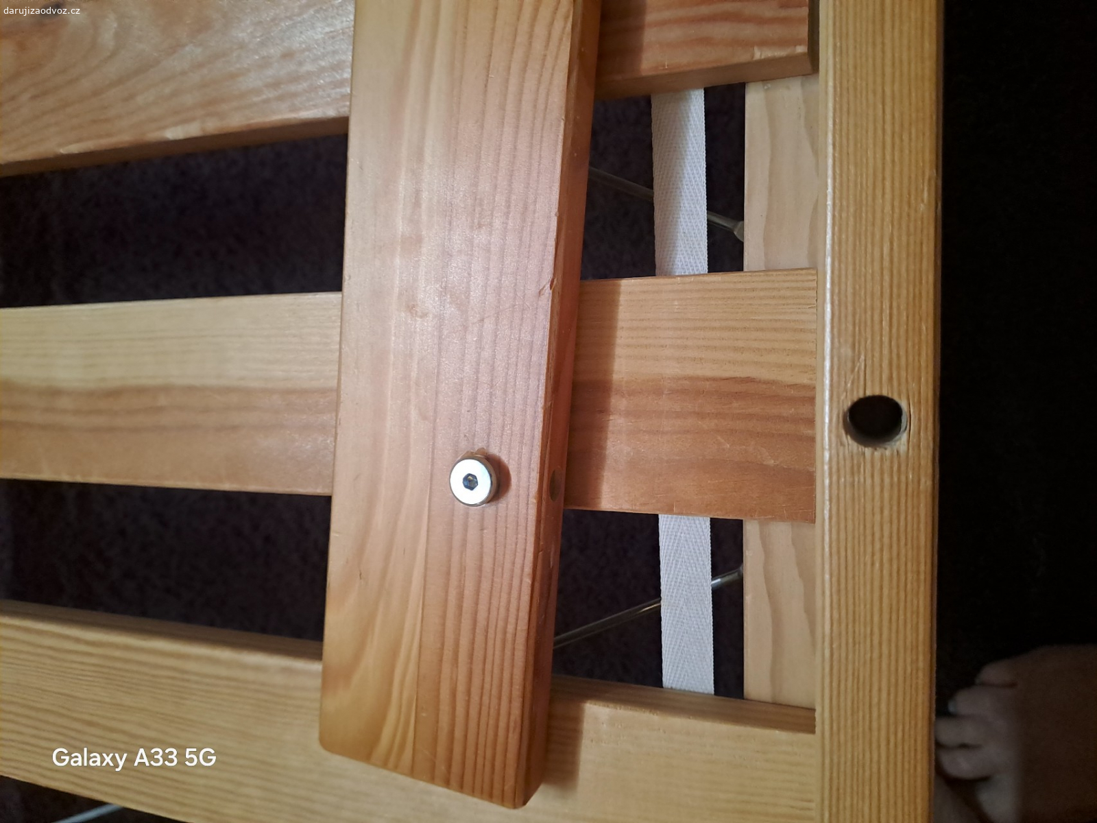 Dětská postel. U boční zábrany chybí šroub. Rýhy v bočnici.