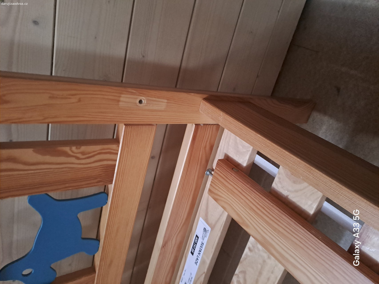 Dětská postel. U boční zábrany chybí šroub. Rýhy v bočnici.