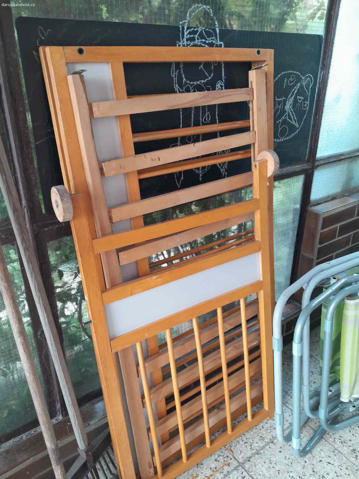 Dětská postýlka. Daruji dětskou postýlku, dřevěná, s kolečky, kompletní se spojovacími prvky, s roštem, bez matrace.