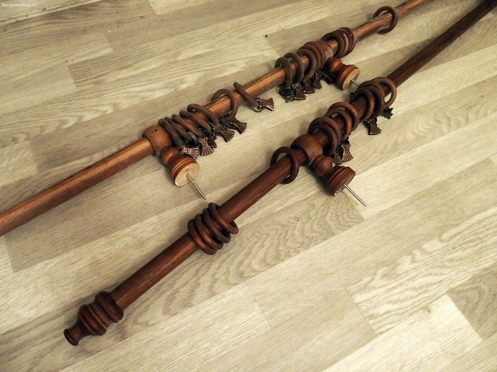 Dřevěná garnýž 153 + 181 (+2 x 4.5) cm. Daruji za odvoz (Brno-Bystrc, Kuršova) dřevěnou garnýž ze dvou částí (spojí se v prostředním ze tří úchytů do stropu) o délkách 153 a 181 cm, ozdobná zakončení to protáhnou ještě o 4.5 cm na každé straně. Na garnýži je 20 kroužků se žabičkami na uchycení závěsu a 10 kroužků volných.