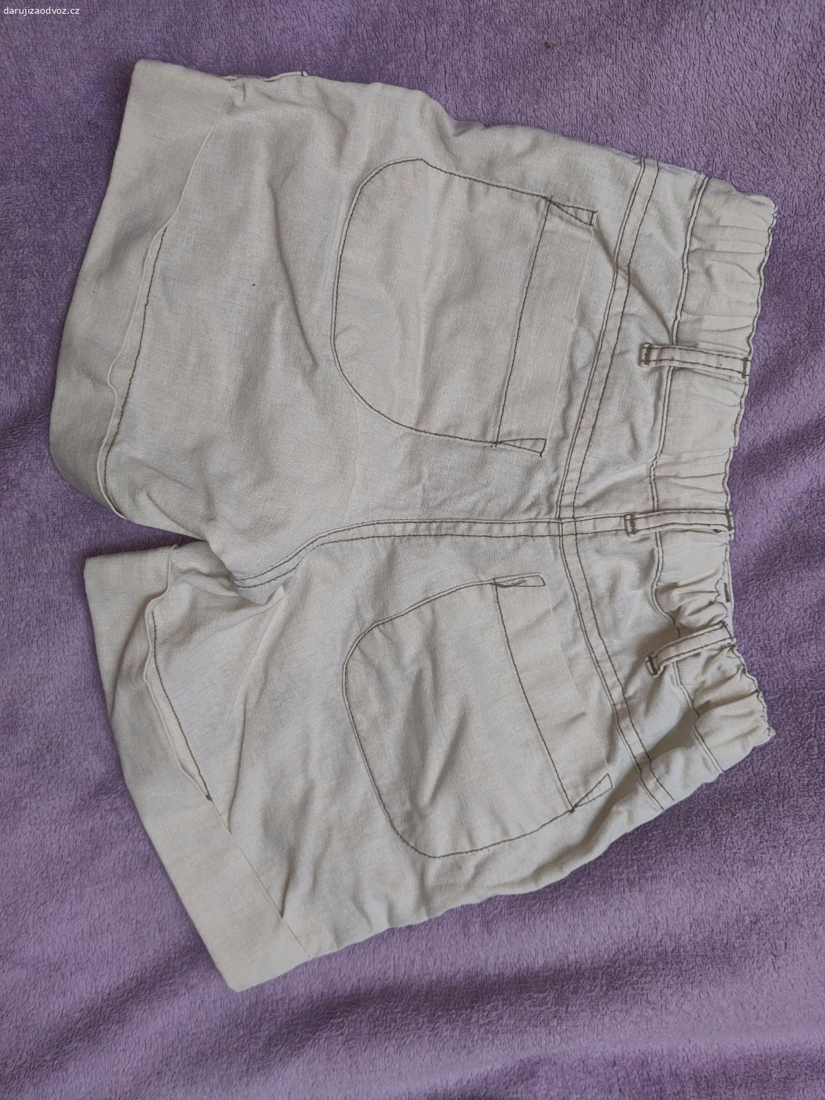 Kraťasy 128. Dobrý den daruji pěkné světlé kraťasy s nášivkou. Po straně chybí jeden knoflíček. 4 kapsy. Cherokee. V pase stahovací gumičky.