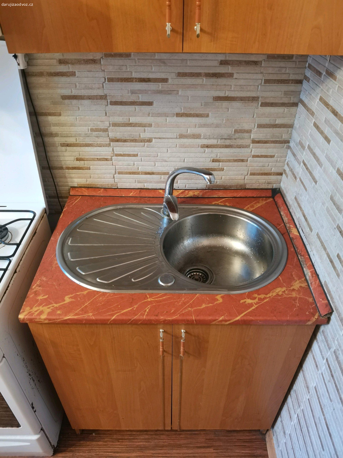 Kuchyň včetně dřezu + skříňka. Drobné vady jedno madlo a uražený roh jednoho šuplíku.