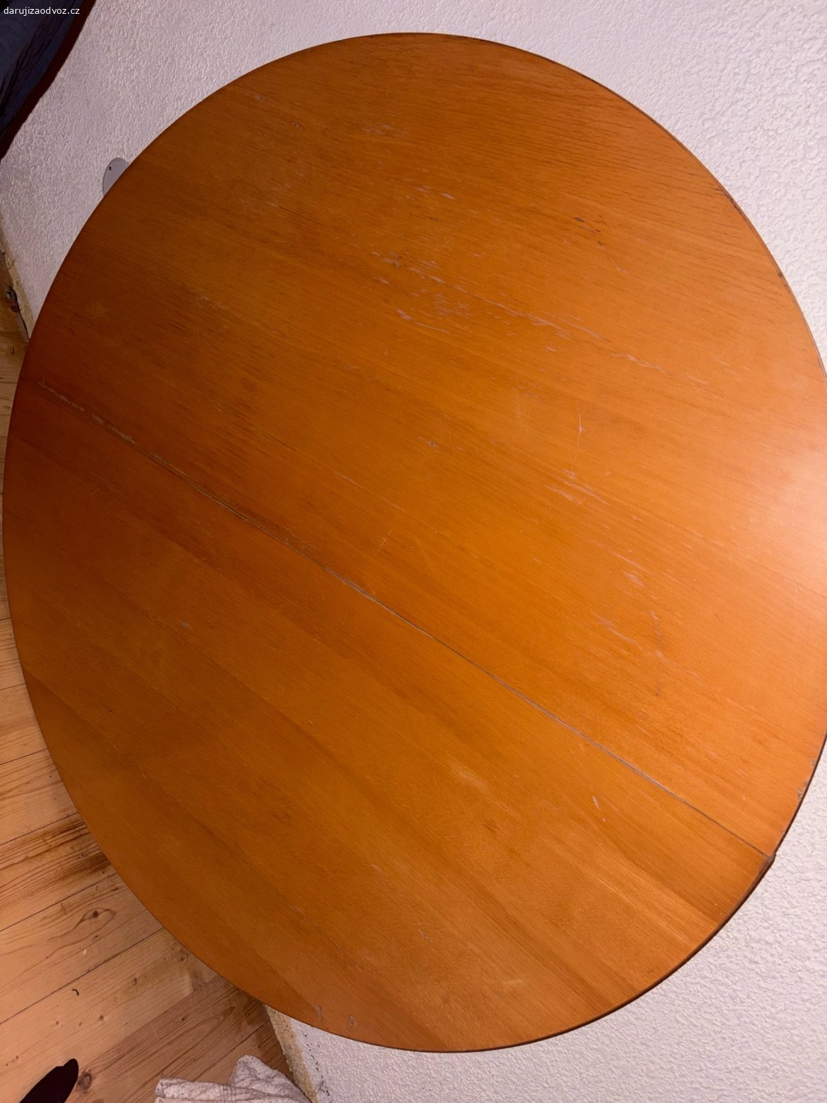 Kulatý jídelní stůl. Daruji jídelní kulatý stůl, průměr stolu je 120cm. Je v zachovalém stavu, pouze na jedné straně má rýhy viz foto. Stůl se nekýve, je stabilní.