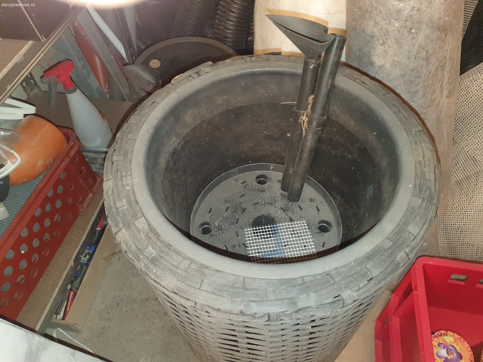 Obaly s kvetinacem. Dva proutěné vysoke obaly se samozavlazovacimi kvetniky uvnitř. Větší výška 77 cm, šířka 40 cm. Menší výška 55 cm, šířka 30 cm. Na fotce že sklepa zkreslené bleskem, skutečná barva šedá až černá.
