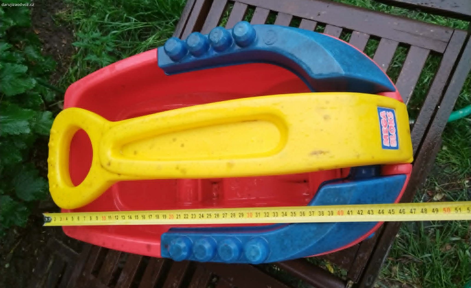 Plastový tahací vozík Mega Bloks – bez kostek. Daruji (ovoce pro děti potěší, není podmínkou) dětský tahací vozík značky Mega Bloks (Mattel). Vozík je používaný, nese známky hraní viditelné na fotkách, ale je plně funkční, robustní, plast nikde nepraskl, poslední dobou byl na zahradě. Má sklápěcí žluté madlo a modré bočnice s výstupky, na které lze kostky přímo stavět. Ideální jako úložný box na hračky nebo na převážení venku. Předám Praha 10-Strašnice, samostatně BEZ stavebních kostek.