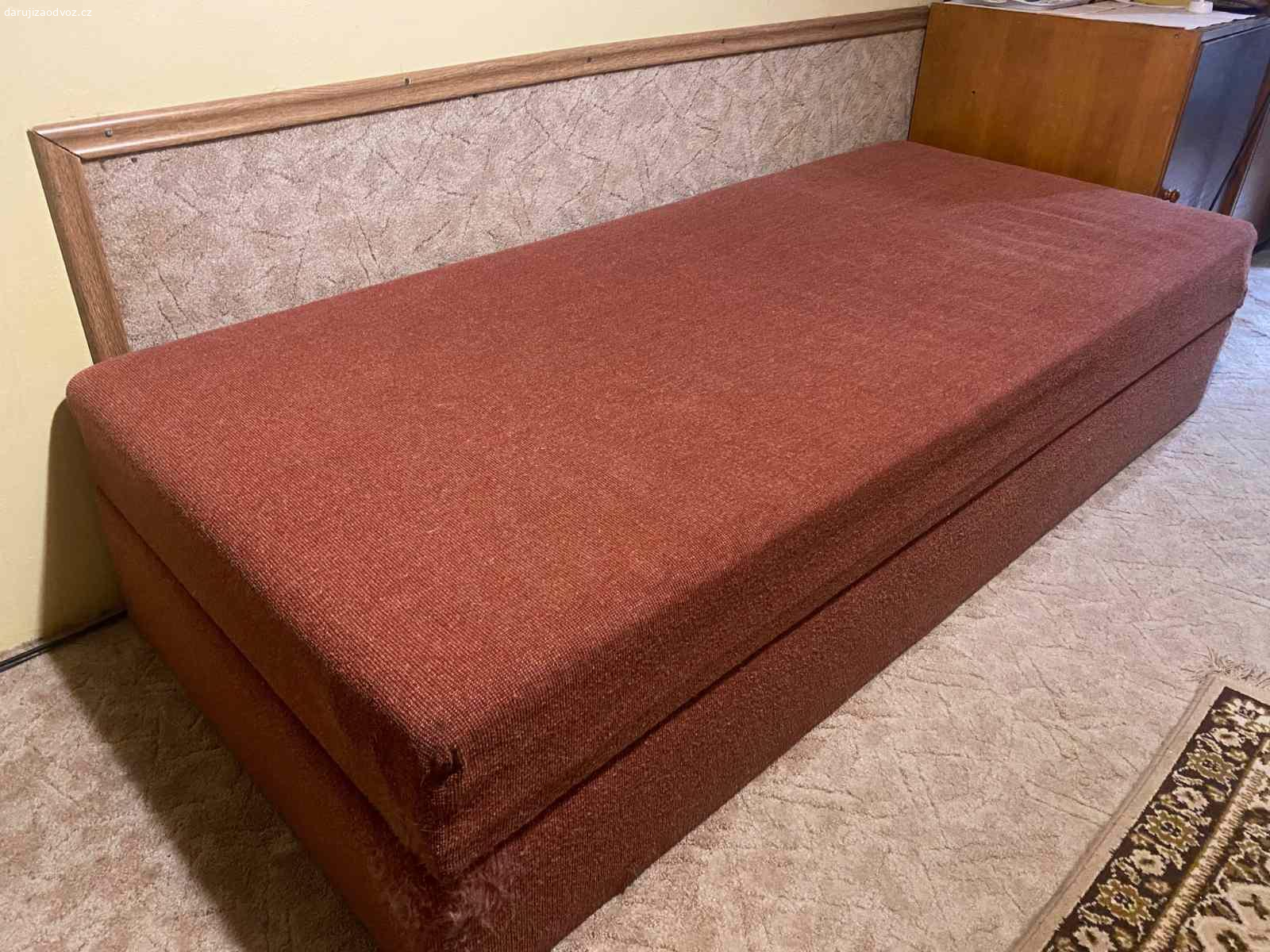 Postel s úložným prostorem. Darujeme za odvoz postel vyklápěcí s úložným prostorem. Rozměry 195 x 85 x 42 cm (zavřená). Látka v rozích poškrábaná kocourem (asi možno esteticky ošetřit), jinak v dobrém stavu, praktická  a s hezkým materiálem potahu. Při odvozu nutné snést z 11. patra s výtahem.