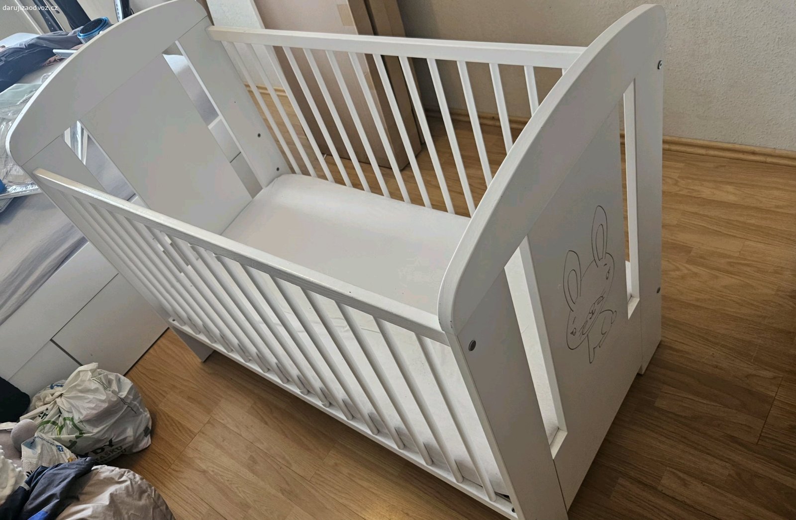 Postýlka se šuplíkem + matrace. Bílá postýlka 120 × 60 cm se šuplíkem, gravírovaný zajíček na čele, zaoblená čela, matrace k tomu. Znaky běžného užívání, jinak v naprostém pořádku.