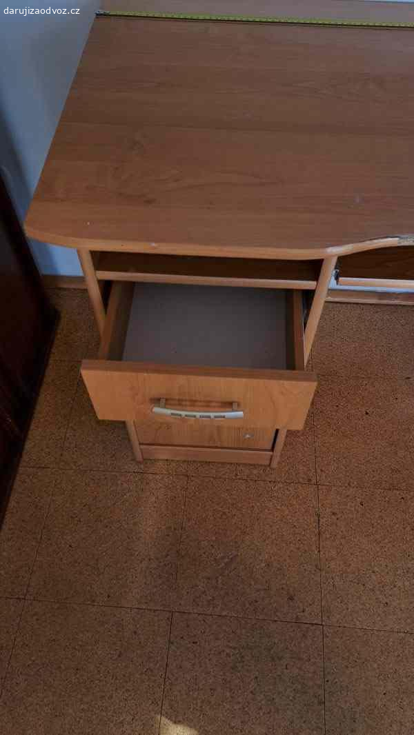 Psací stůl. Psací stůl v laminu - barva třešeň, se zásuvkou, úložným prostorem na levé straně a odkladným prostorem uprostřed, v rozměru š 100cm. Na předním části částečně odtržená lamino páska. Stůl ve smontovaném stavu. Vlastní odvoz.