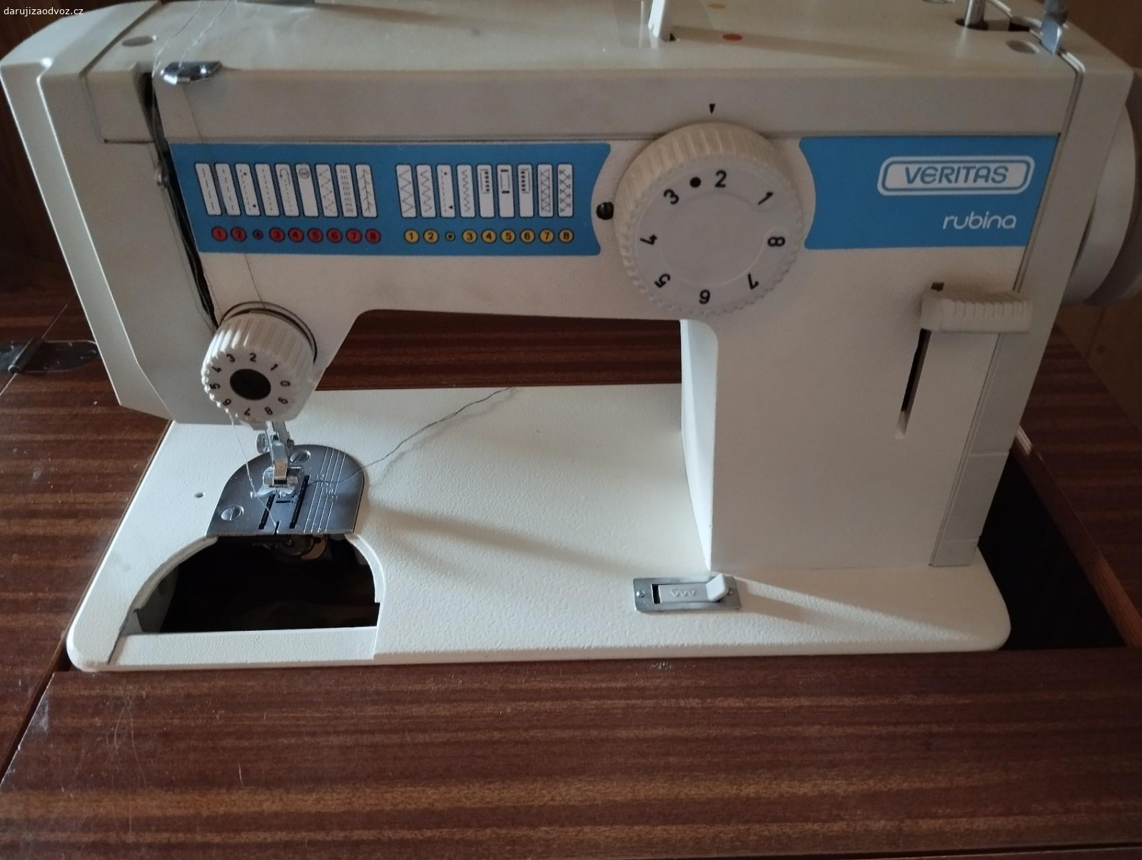 Šicí stroj Veritas. u skříňky chybí kliček na zamknutí a u stroje jeden plíšek viz foto. Jinak je stroj plně funkční