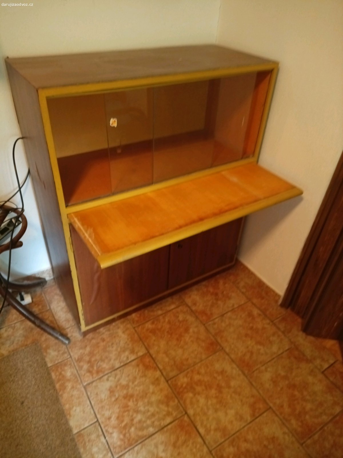 Skříňka. Skříňka s prosklením a vysouvací deskou. Je potažená tapetou a hůře se otevírá sklo. rozměr: v. 109, š. 90, hl. 40
