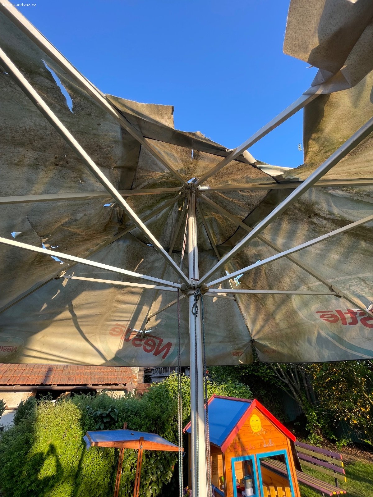 Slunečník. Mechanicky stále funkční “hospodský” slunečník. Třeba ještě někdo zvládne nově potáhnout. Rozměr 2,8 x 2,8 x 3m ( š x š x výška).