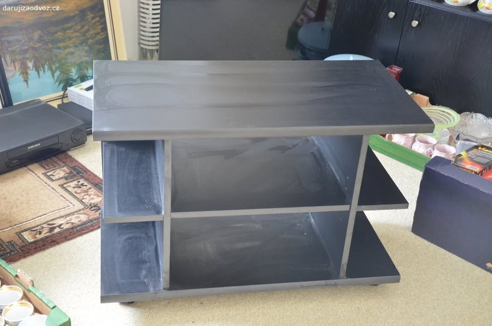 SPĚCHÁ: Daruji TV skříňku. Nabízím černou televizní skříňku na kolečkách - za odvoz. Rozměry: š 79 cm, v 55 cm, h 40 cm. Šmouhy na fotografiích jsou pouze stopy do prachu, lze snadno otřít.