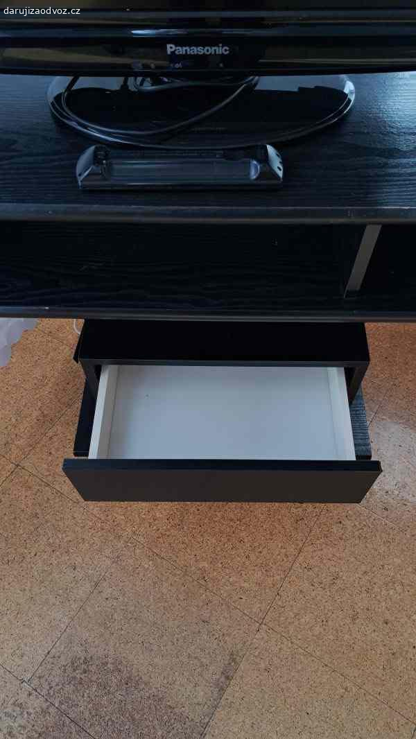 TV stolek. Daruji zajímavě řešený TV stolek s několika patry v tmavém provedení s podstavcem na 4 kolečkách a se šuplíkem. Rozměry š 40cm, d 80cm,výška 70cm. Vlastní odvoz.